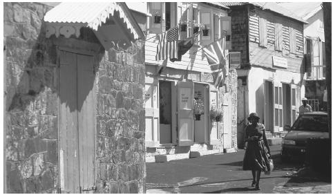 A woman walks along a narrow street in the town of Plymouth.