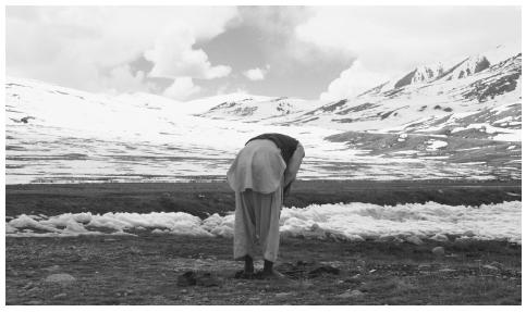 A muslim bows his head in prayer on the snow-capped mountain  border of Pakistan, China, and Afghanistan. Both the Sunnis and the  Shiites recognize the authority of the Koran and respect the five  pillars of Islam.
