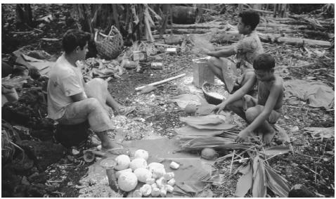 A group of Samoan men prepare an earth oven for use. In  traditional Samoan culture, men were responsible for daily cooking and  preparation of special events.