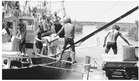 A traditional pearling lugger is loaded with supplies at  Streeter's Jetty.