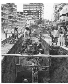 Road workers undertake construction work in Decca. Laborers make up the vast majority of workers in urban areas.