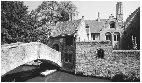 A stone bridge crossing a canal in Bruges. The north part of Belgium consists of isolated farms between villages, while the south tends to contain larger groups of farms.