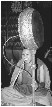 A young monk playing a drum. The national religion is the Vajrayana form of Mahayana Buddhism.