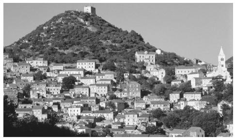 Stone houses with terracotta roofs cover a hill in the town of Lastovo on the island of Lastovo.