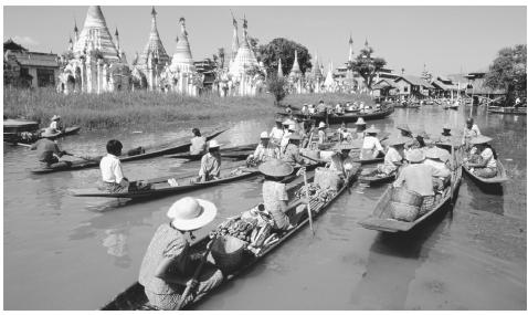 Small boat traffic on Lake Inle. Men are primarily responsible for the transportation of commercial goods.