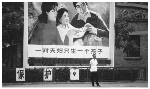 A man stands in front of a family planning billboard in Beijing. Due to China's huge population, most families are allowed to have only one child.