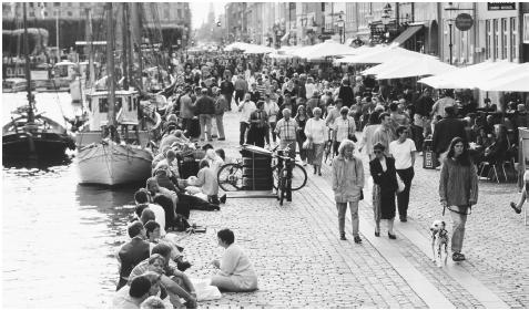 Crowds of tourists and Copenhagen residents mingle along the Stroget, a mile-long pedestrian street along the harbor.