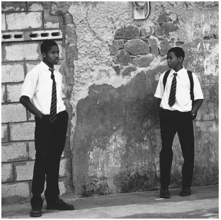 Uniformed schoolboys wait for the bus in Roseau. Opportunities for education after age fifteen are limited.