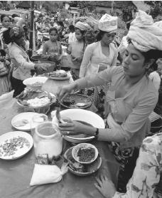 A woman serves food at a market stand. Urban Indonesian women often find work in markets.