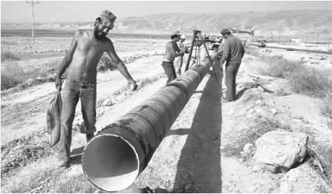 Workmen lay a water pipeline in the Jordan Valley. Most of Jordan is desert.