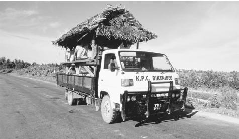 A new home in transit on the back of a truck in Tarawa. Rural houses are built with traditional materials while imported materials are used for homes in towns.