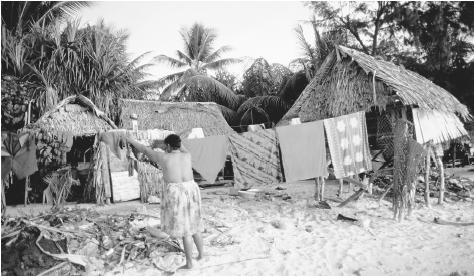 Beach houses in Tarawa, Kiribati, consist of thatched roofs and native wood.