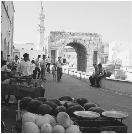 Men gather with carts of melons near the Roman arch dedicated to Marcus Aurelius in Tripoli.