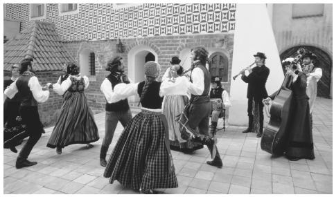 A group of Lithuanian folk dancers and musicians perform in a Vilnius public square.