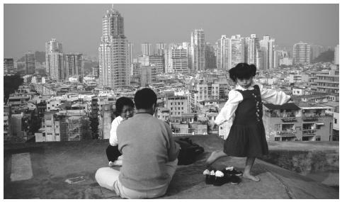 A family relaxing on a rooftop overlooking the cityscape. Despite continued Chinese dependence on larger, extended families, the nuclear family is most pervasive in Macau.