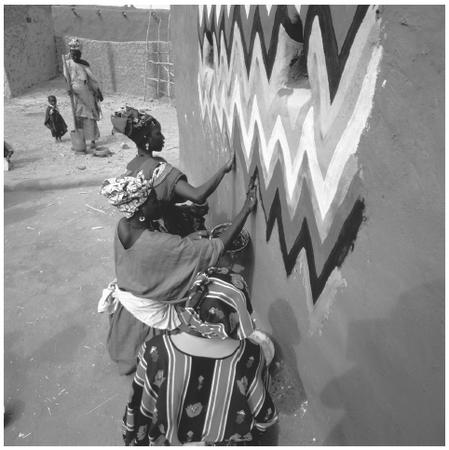 A group of women painting a hut. Mauritanian houses have few wall decorations and sparse furniture.