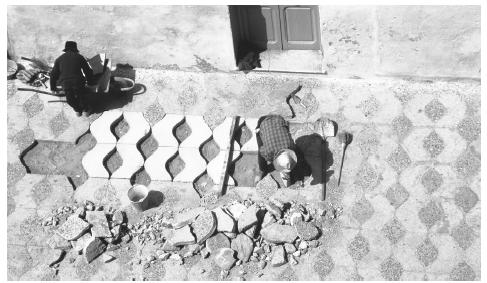 Workers replacing tiles on a Moroccan street.