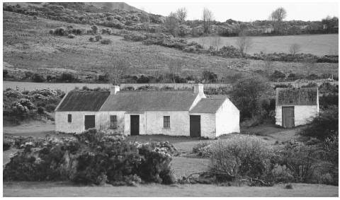 Farmhouse in mountains of Mourn. Northern Ireland has lush green countryside and stout mountains leading to a steep and craggy shoreline.