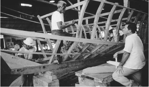 Men building a wooden boat. Fish are Palau's main export, and the annual catch may be up to 780,000 pounds (291,000 kilograms).