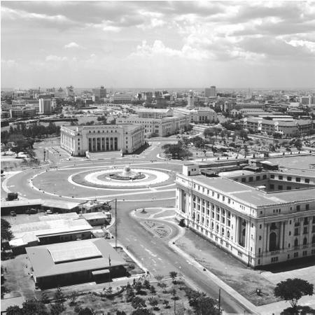 A roundabout with a fountain sits between old buildings in Manila. Some areas of the city were destroyed during World War II, when the country was invaded by Japan and then liberated by the United States.