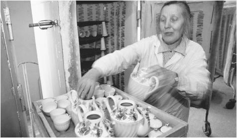 A woman places teapots and teacups in a cabinet, possibly for  drying, at the Lomonosov Porcelain Factory. Unemployment for women has  increased in the 1990s, especially in the manufacturing sector.