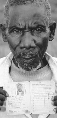 A Batwa holds up his identity card, which notes his ethnic origin. The Batwa have been subject to much discrimination in Rwanda.