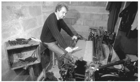 A weaver sits at his loom to weave Harris Tweed, Harris Island, Outer Hebrides. The textiles industry was predominant until 1900.