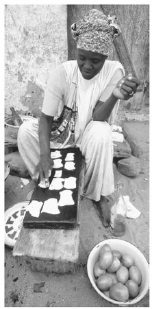A woman making fish pastilles on the street, Goree Island. Fish products are a major export.