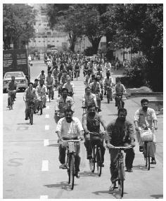 Workers riding bicycles to Sembahong Shipyard, one of the two repair facilities in Singapore. Cars are a symbol of wealth and status.