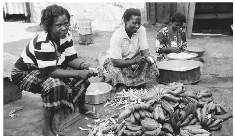 Women preparing food in Kampala. All meals are prepared by women in Uganda; boys over age twelve are banned from the kitchen.