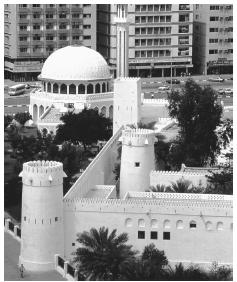 An old fortress surrounded by modern buildings in Abu Dhabi. After 1960, mud-walled communities transformed into commercial centers.