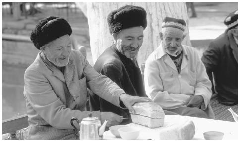 A man cuts bread in a choyhana, or tea house. The tea house is the central gathering place for Uzbek men.