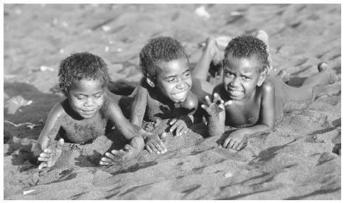 Children from the Jon Frum Cargo Cult Village play in the black sand beach on Tanna Island, which is a short distance from the active volcano Yasur. Vanuatu is a mostly volcanic archipelago of over eighty islands.