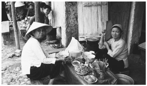 Hai người phụ nữ ngồi xuống ăn sáng tại Việt Nam. Trong khi phụ nữ có vai trò quan trọng trong gia đình, tình trạng của họ trong kinh doanh và chính phủ là ít quan trọng hơn so với nam giới.
