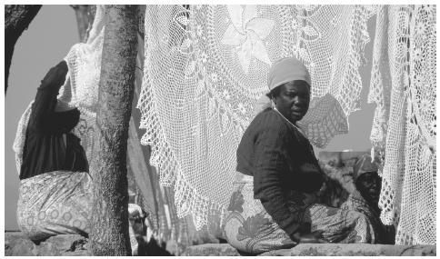 A woman selling crocheted tablecloths in Harare. Many enterprises in the informal sector are based on women's traditional activities.