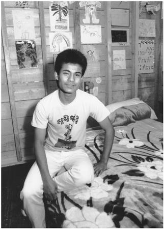 Actor Virak Ui is sitting on the set of a Cambodian home at Boston's Children's Museum. The exhibit, called "From Time to Time: Celebrating 75 Years at Our House," traces the city's diverse immigration history.