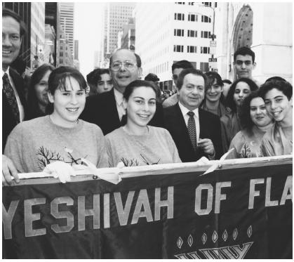 U. S. Senator Alfonse D'Amato (left center), comedian Jackie Mason (center), and others celebrate the annual Salute to Israel Parade in New York City.