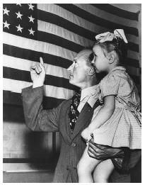 In this 1949 photograph, a Latvian immigrant explains the meaning of the American flag to his daughter upon their arrival in the United States.