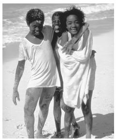 A group of smiling Cayman Island children playing on the beach. There is no natural freshwater on the islands.