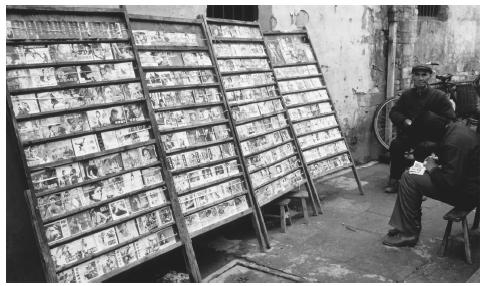 A merchant rents books from a sidewalk rack on a street in Tunxi.