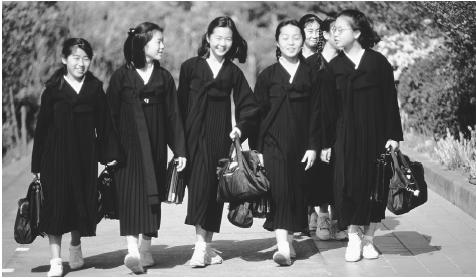A group of North Korean girls walk to school. Education in North Korea is geared toward furthering the influence of state socialism.