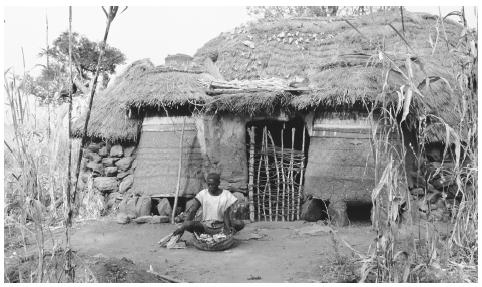 A man sits in front of his farmhouse in Toro, Nigeria. Traditionally, only men own land.