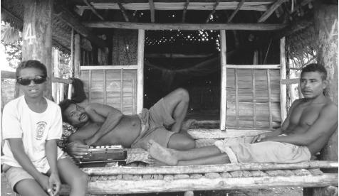 Three men in a bachelor house in Omarakana, Kiriwina, Trobriand Island. Traditionally, even married men lived in separate houses from their wives.