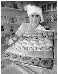 Norik Shahbazian, a partner in Panos Pastries, shows off a tray of several varieties of baklava and tasty Armenian desserts.