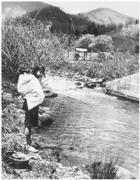 This young Cherokee woman demonstrates a method of fishing using a stick.