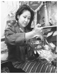 Gelmu Sherpa rubs a "singing bowl" which resonates with a soft hum in her shop on New York's Upper  West Side.