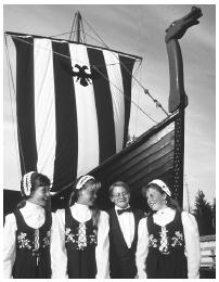 These Leikarring Norwegian Dancers are standing in front of a replica of the Valhalia Viking ship in Petersburg, Alaska.