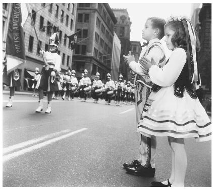In this photograph, taken in 1964, six-year-olds Leonard Sikorasky and Julia Wesoly are watching the Pulaski Day Parade in New York City, which commemorates the death of the Revolutionary War General Casimir Pulaski.