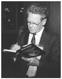 Theologian Hans Kung signs one of his books during the 1993 Parliament of World Religions in Chicago.